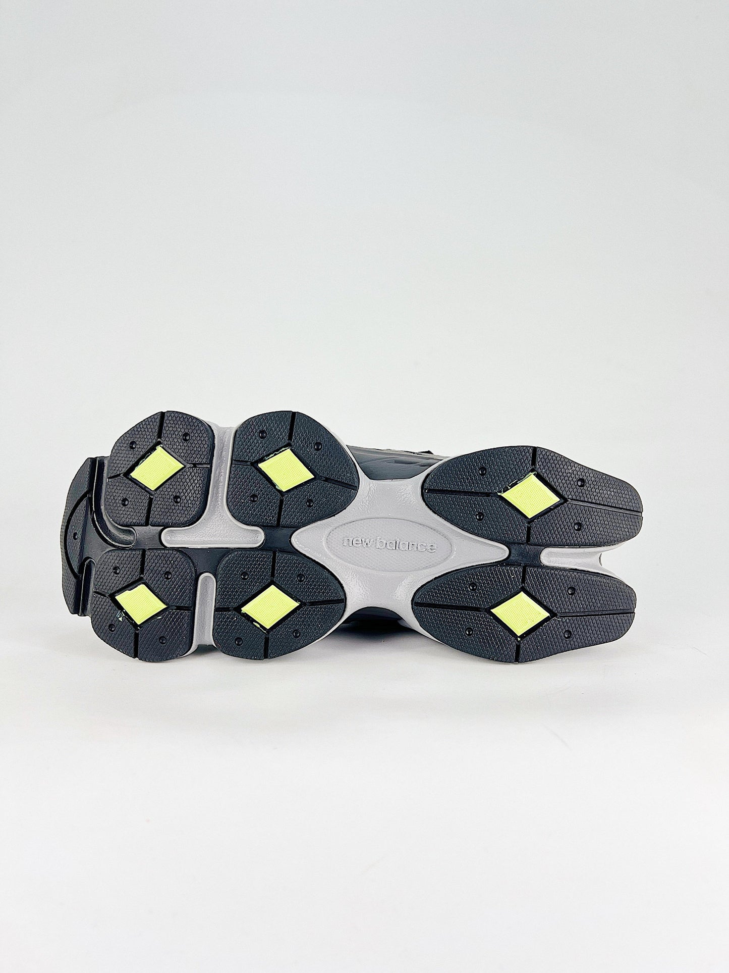 New Balance 9060 sneakers shown are in a black and cement colorway, often featuring a durable mesh and suede construction with Lime accents