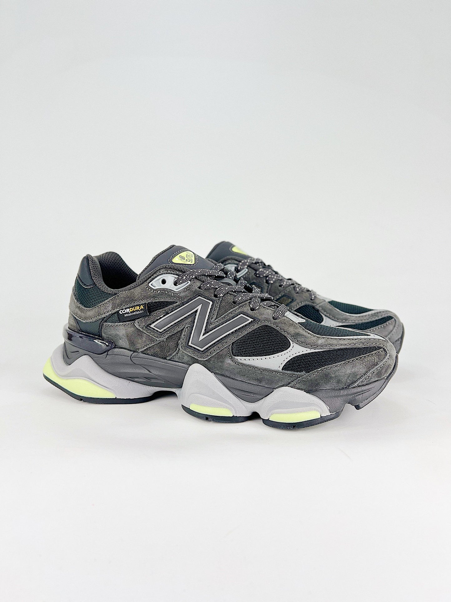 New Balance 9060 sneakers shown are in a black and cement colorway, often featuring a durable mesh and suede construction with Lime accents