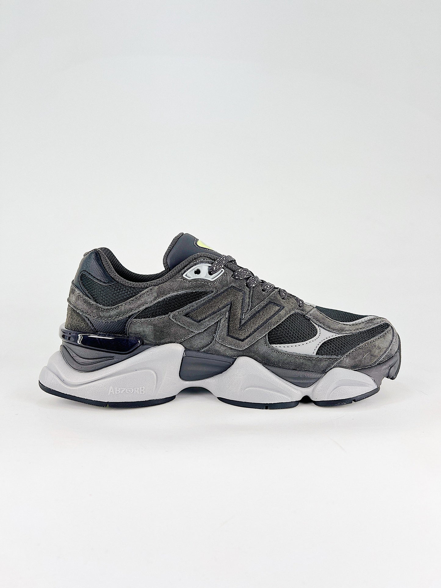 New Balance 9060 sneakers shown are in a black and cement colorway, often featuring a durable mesh and suede construction with Lime accents