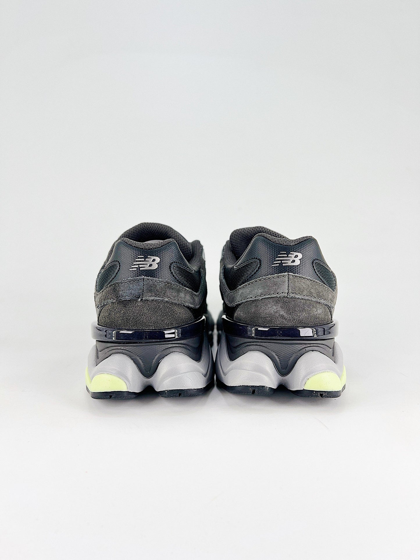 New Balance 9060 sneakers shown are in a black and cement colorway, often featuring a durable mesh and suede construction with Lime accents